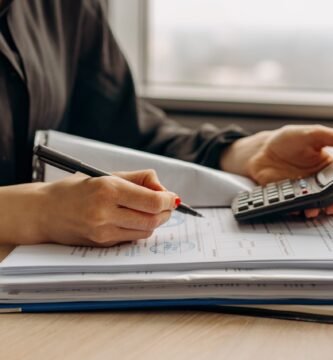 Obraz mężczyzny obliczającego swoje podatki za pomocą kalkulatora