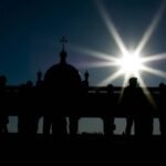 Obraz na ciemnym tle przedstawiający grupę ludzi w budynku